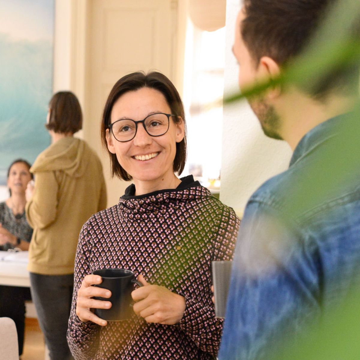 Teilnehmende im Gespräch bei einer Kaffeepause im Institut